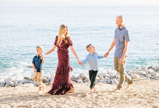 Nicole Neves walking on a beach with her two sons and husband