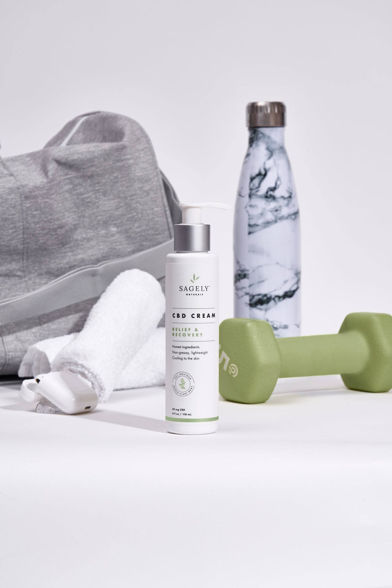 Sagely Naturals CBD Cream with gym bag, water bottle, towel and dumbell in background.