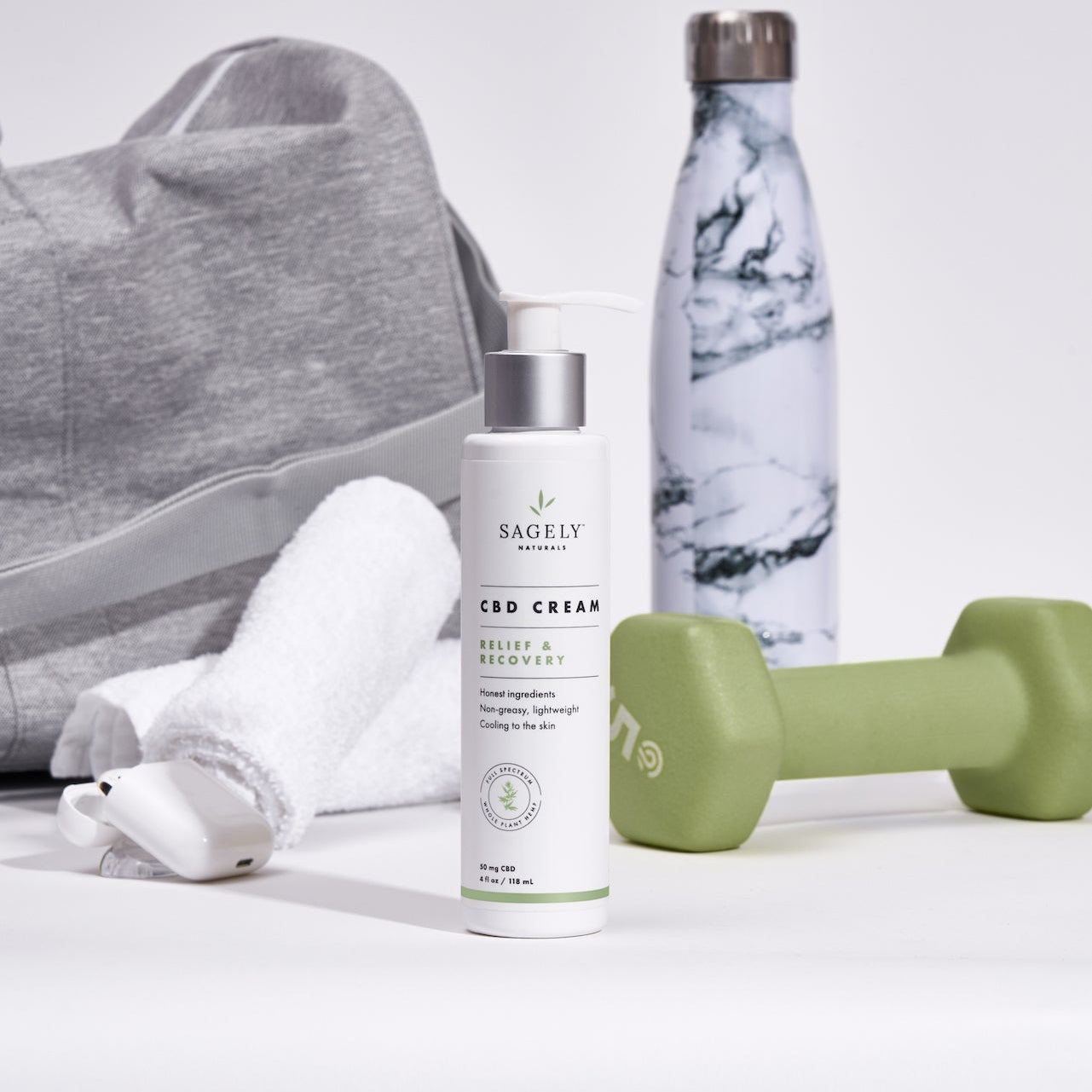 Sagely Naturals CBD Cream with gym bag, water bottle, towel and dumbell in background.