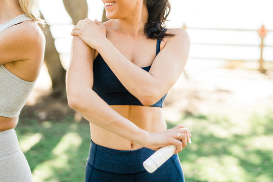 A woman in workout wear rubbing Sagely Naturals CBD cream into her shoulder.