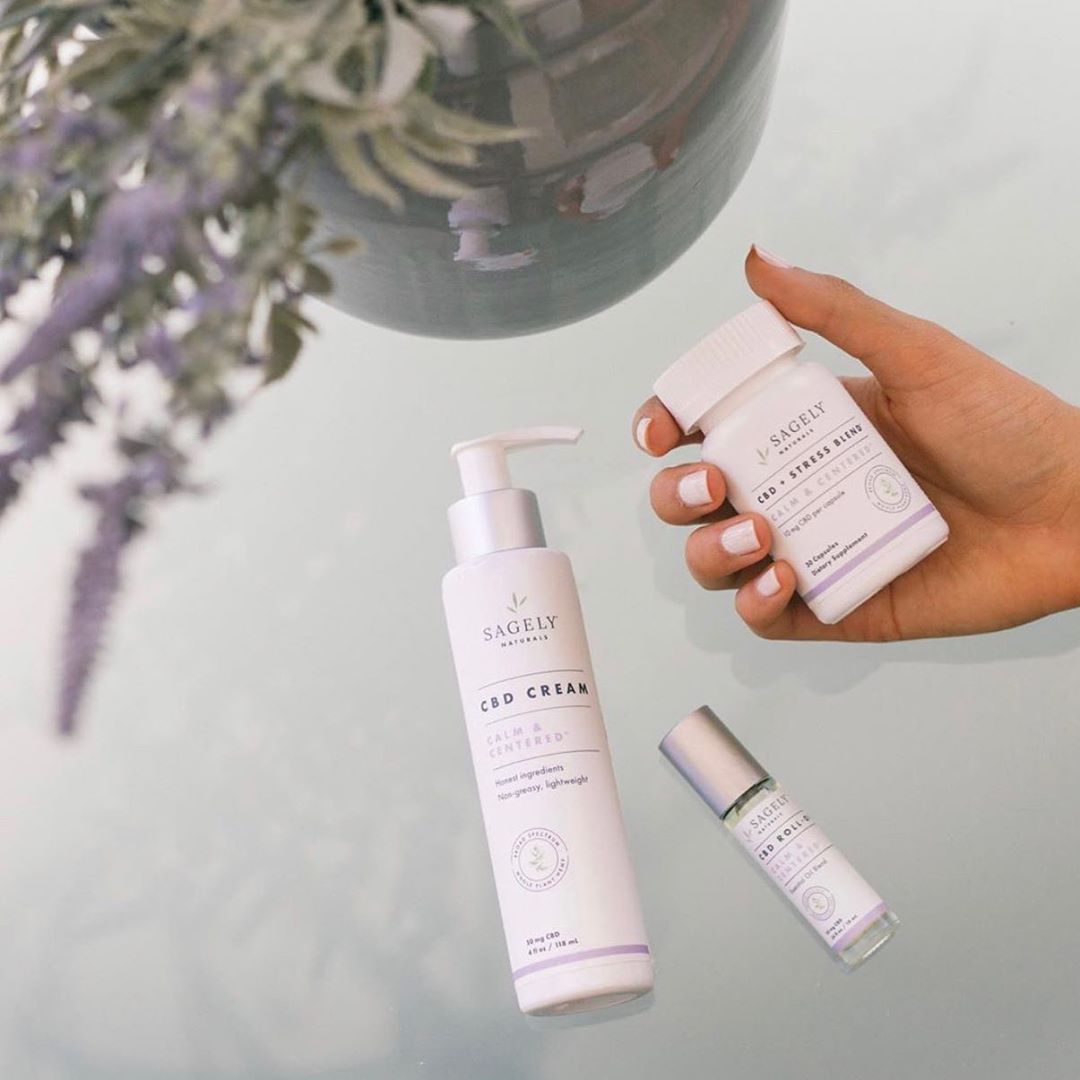 Sagely Naturals Calm & Centered Cream, Capsules & Roll-On next to a lavender plant.