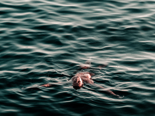A photo of someone floating on their back in an ocean