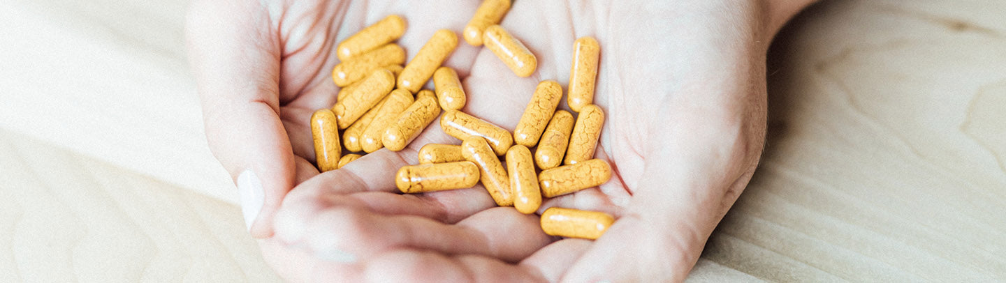 Sagely Naturals CBD + Turmeric capsules being held in hands