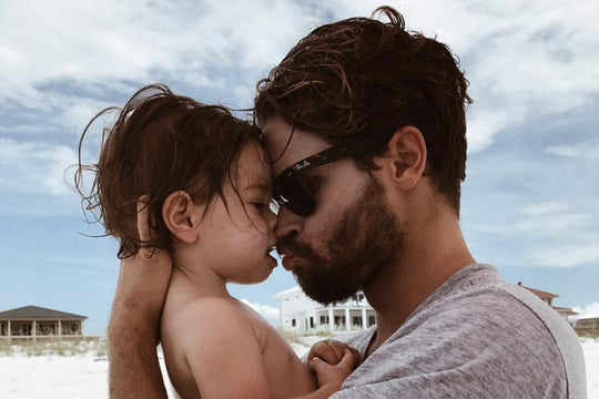 Sterling Spencer holding his son on a beach.