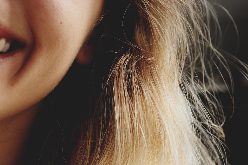 Woman smiling with hair catching in the sunlight.