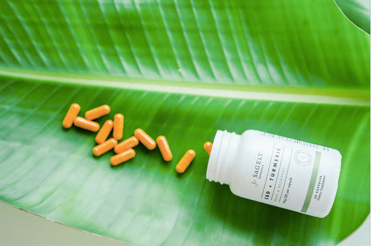 Sagely Naturals CBD Capsules being poured out onto a palm leaf