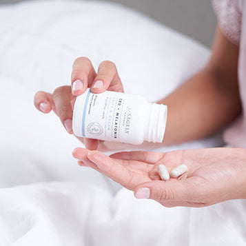 Woman taking Sagely Naturals Drift & Dream CBD Capsules
