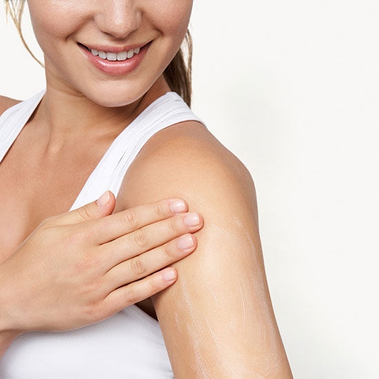 Woman rubbing Sagely Naturals Relief & Recovery CBD cream on her shoulder